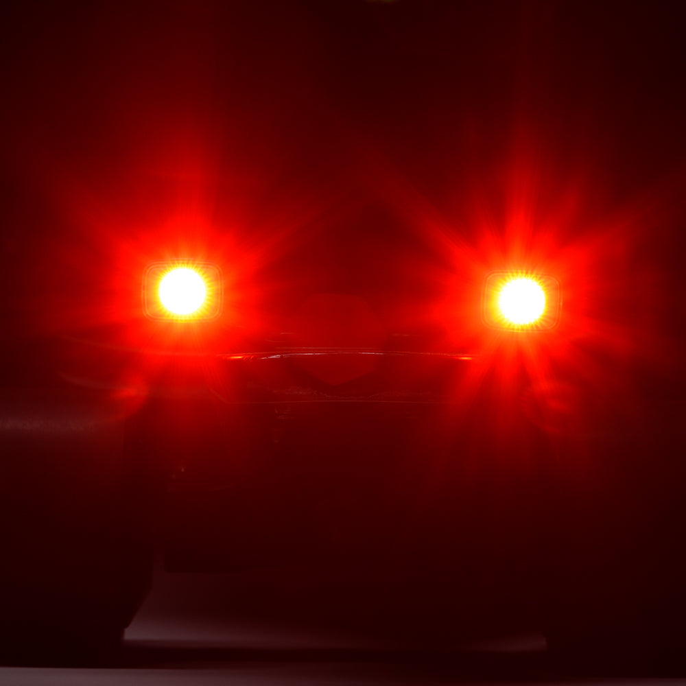 Two red lights glowing intensely in a dark setting