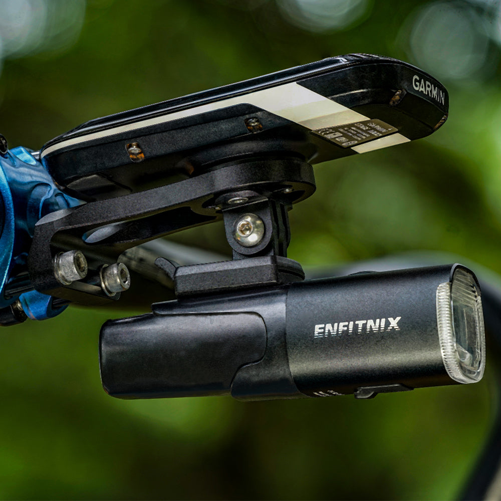 Garmin device on a bike handlebar with Enfitnix light in the foreground, blurred green background
