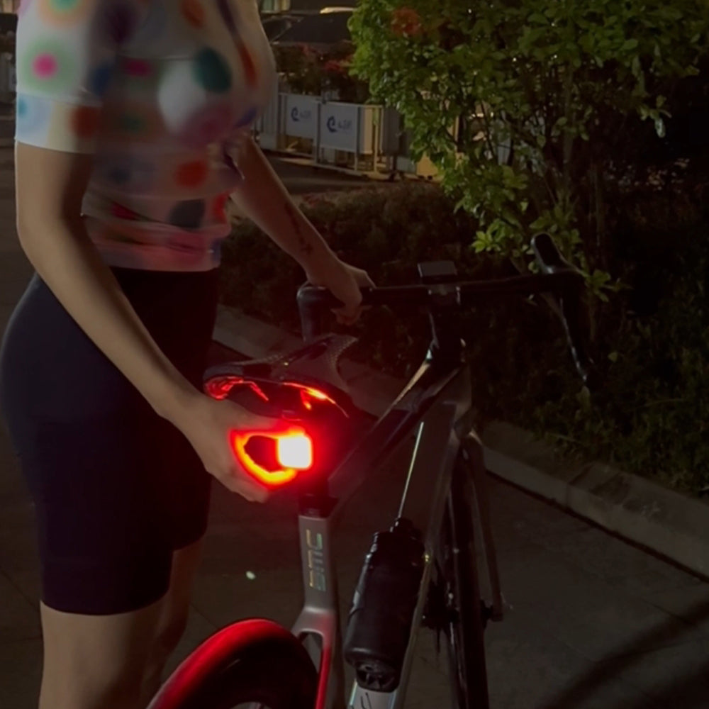 Person adjusting a bicycle light outdoors