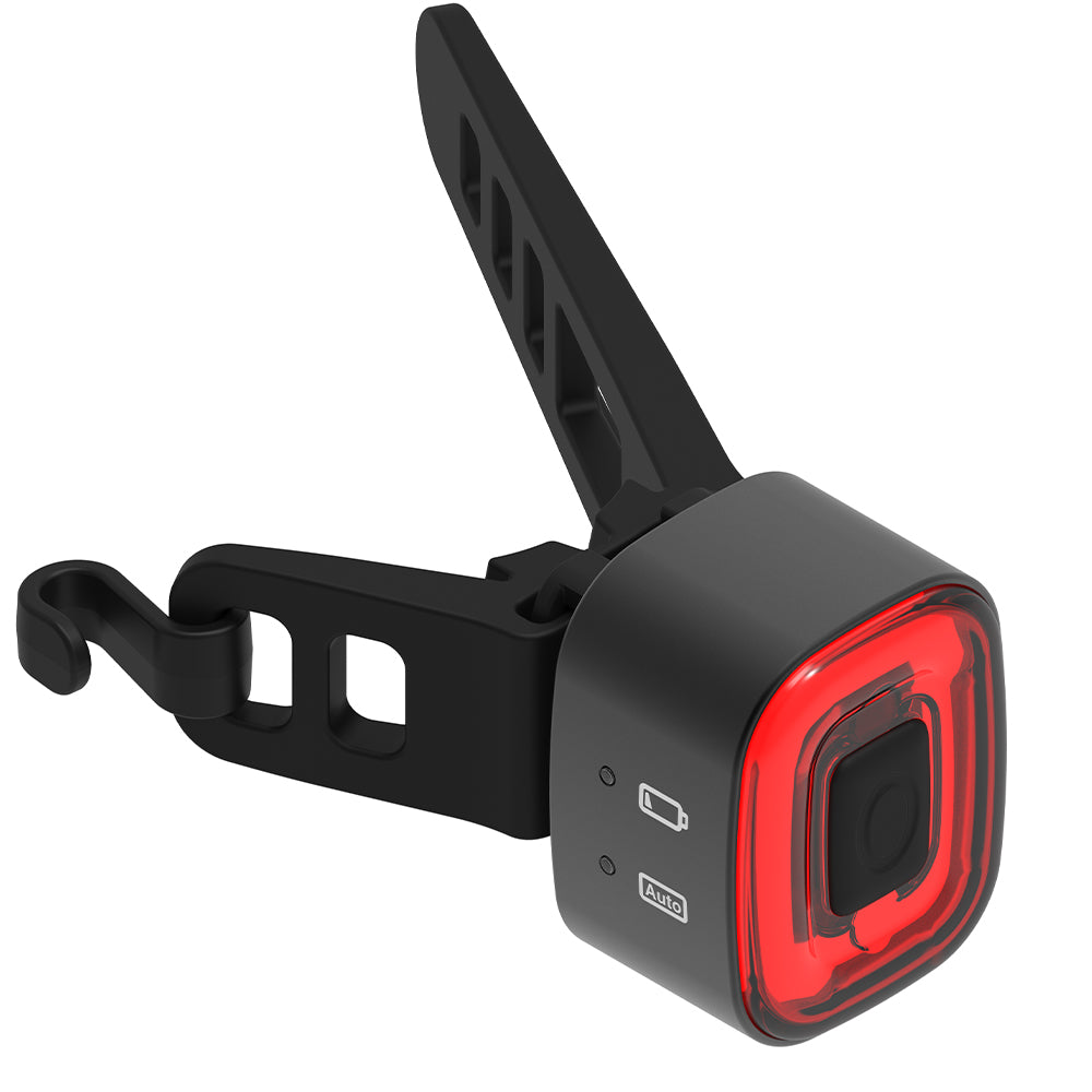 Black bike tail light with red lens on a white background