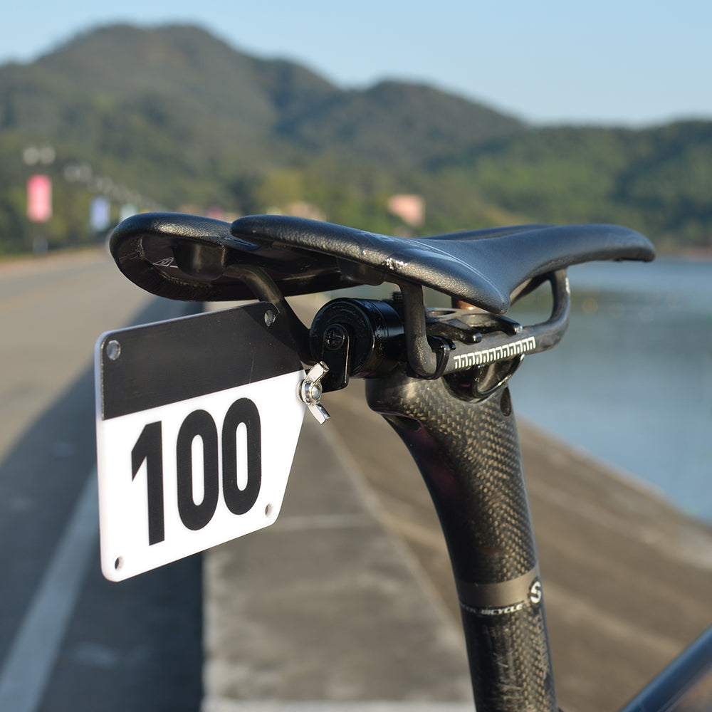 Bicycle seat with number plate against a scenic background