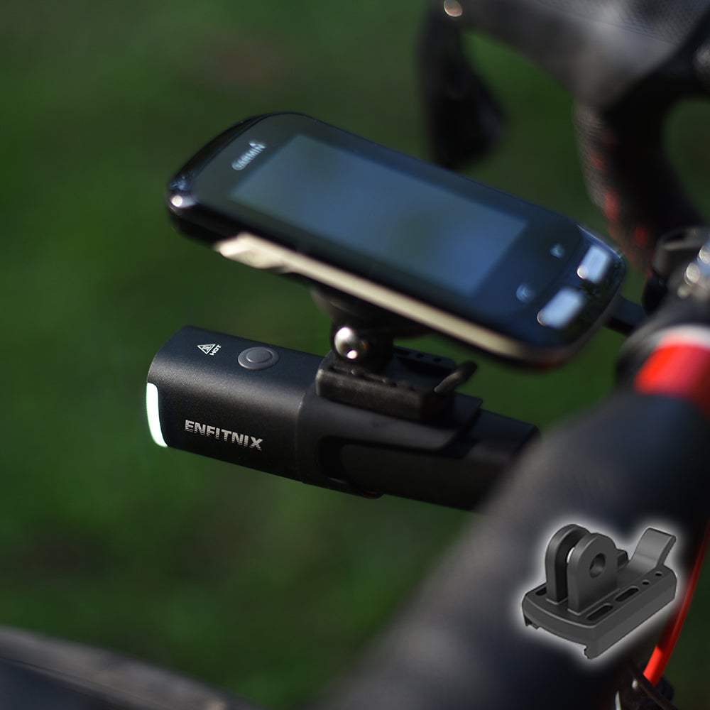 Smartphone mounted on a bike handlebar with a light attached, on a blurred green background.