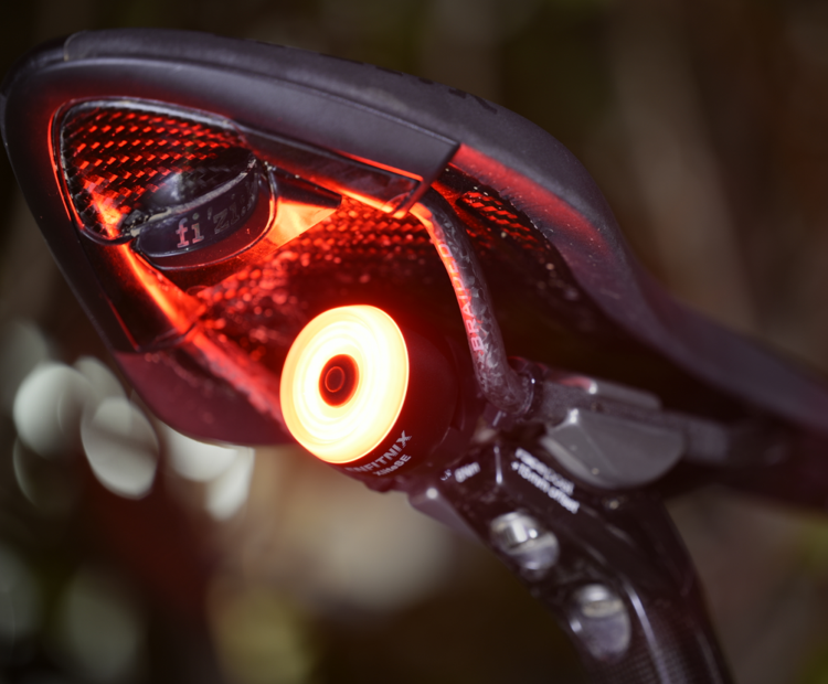 A xlitese bicycle taillight emits a bright red light in the darkness