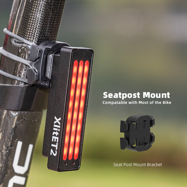Bicycle tail light with seatpost mount bracket on a blurred natural background